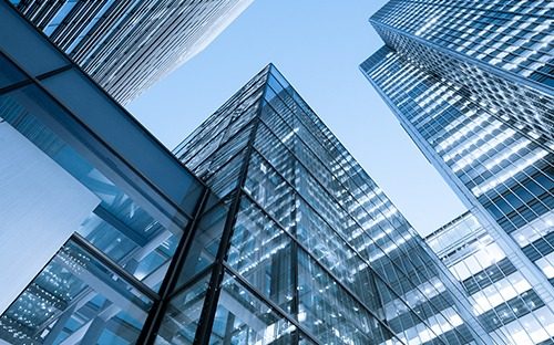 Façades vitrées de gratte-ciel modernes reflétant le ciel bleu en contre-plongée