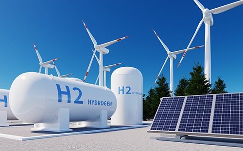 Réservoirs d’hydrogène entourés d’éoliennes et de panneaux solaires sous un ciel dégagé
