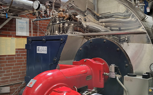 Chaudière industrielle de production de vapeur avec brûleur, instrumentation de pression et réseau de tuyauteries en chaufferie