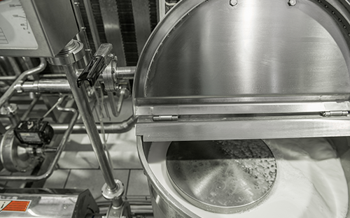 Cuve de process en acier inoxydable ouverte avec réseau de tuyauteries et instrumentation dans un environnement agroalimentaire