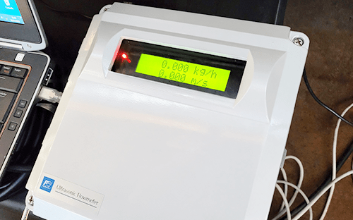 Boîtier d’un débitmètre ultrasonique avec écran rétroéclairé affichant le débit mesuré en temps réel