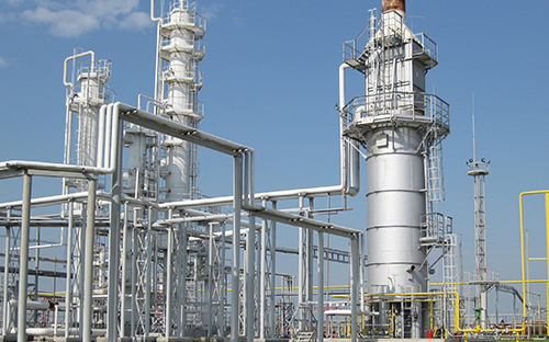 Installation industrielle avec colonnes de procédé, tuyauteries métalliques et équipements de production dans un site énergétique