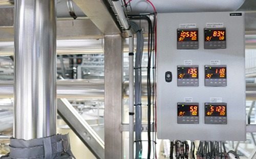 Armadio industriale dotato di diversi regolatori di temperatura PID con display digitali che controllano diversi punti del processo