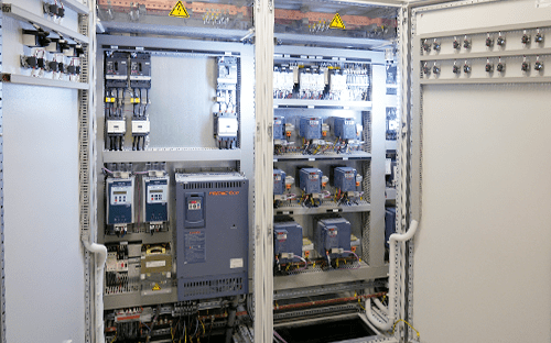 Open electrical cabinets incorporating several Fuji Electric frequency converters with protections, terminal blocks, and industrial cabling