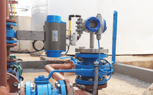 Industrial installation with hydrostatic level sensor mounted on a pipe and connected to a tank for pressure measurement