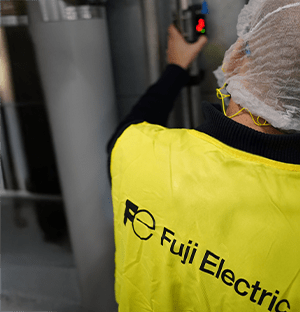 Technician equipped with PPE installing a flow meter on an industrial installation with on-site parameter control