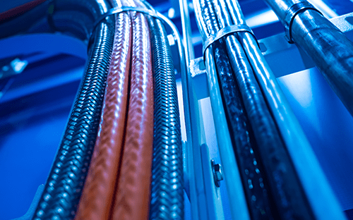 Гибкие электрические кабели в оболочке, установленные в виде пучков в промышленном шкафу, иллюстрирующие кабельную разводку измерительной установки.