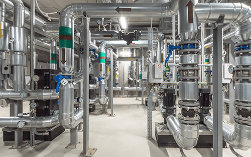 Industrial installation with network of insulated pipes, valves, and equipment illustrating the operating conditions of fluids