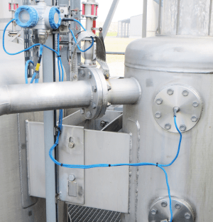 Industrial hydrostatic level measurement system with pressure transmitter to a tank