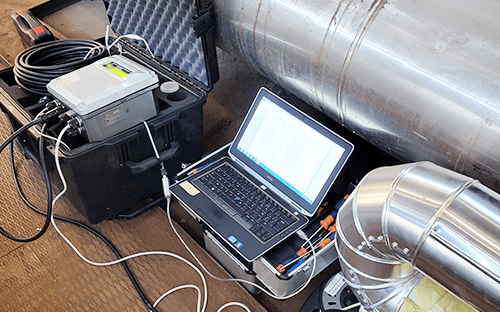 Ноутбук, подключенный к измерительному оборудованию, установленному рядом с паропроводом во время профилактического технического обслуживания.