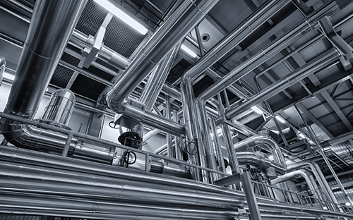 Industrial stainless steel piping network with elbows and valves in a process plant