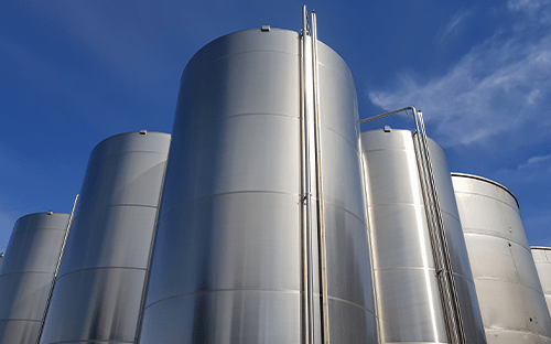 Cylindrical stainless steel industrial tanks used for storing liquids in process facilities