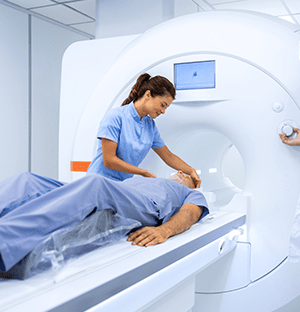 Medizinische Bildgebungsuntersuchung mit Patient, der in einem Scanner liegt, betreut von Pflegepersonal, das die ALARA-Prinzipien anwendet