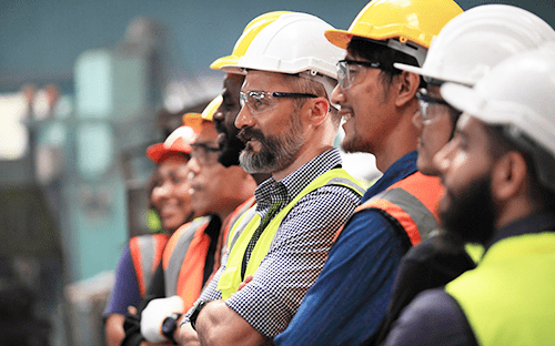 Equipa de técnicos com capacetes e coletes de segurança durante uma formação industrial