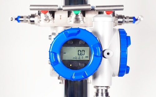Pressure transmitter installed on piping with digital display on blue front panel