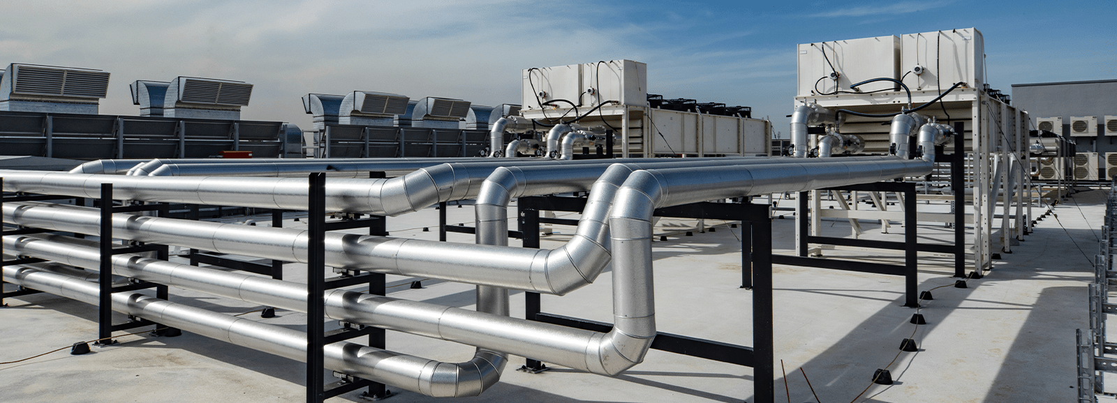 Network of industrial pipes connecting cooling units on the roof of a data center