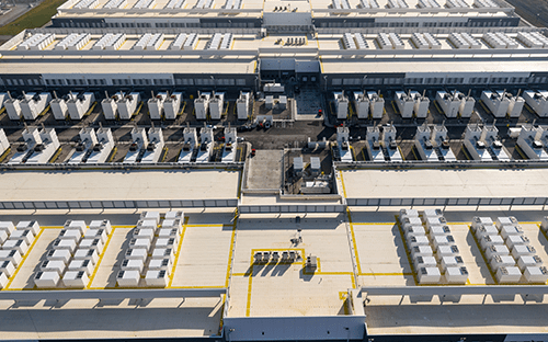 Aerial view of industrial cooling systems installed on the roof of a large technical complex