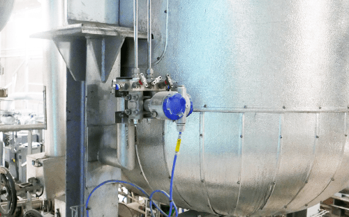 Pressure transmitter installed on an industrial tank with pipes and fittings