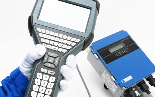 Comunicador HART portátil que muestra los parámetros de configuración en pantalla, con teclado completo y sensor en la parte trasera