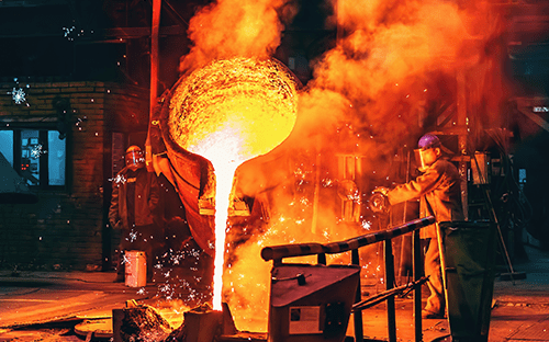 Geschmolzenes Metall wird bei einem industriellen Gießvorgang aus einem Gießpfanne in eine Form gegossen.