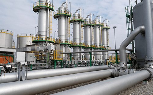 Installation industrielle avec réseaux de canalisations, cuves verticales et équipements de process pour le traitement de fluides