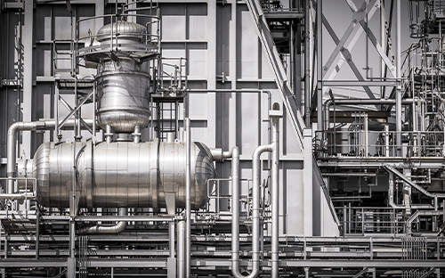 Industrieanlage mit Rohrleitungen und Metallbehältern, die ein Flüssigkeitskreislaufsystem in einer industriellen Umgebung veranschaulicht