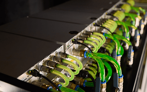 Endüstriyel bir soğutma sisteminde dolaşan yeşil floresan sıvı içeren boru ve bağlantı parçaları ağı