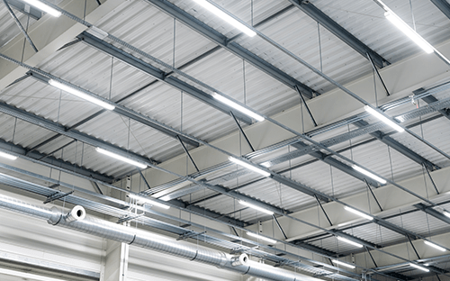 LED-Industriebeleuchtung, installiert unter einem Stahlträger in einer Produktionshalle