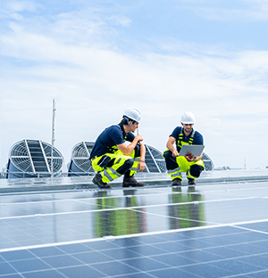 Techniker, die Solarmodule auf einem Industriedach überprüfen, um die Energieerzeugung zu überwachen