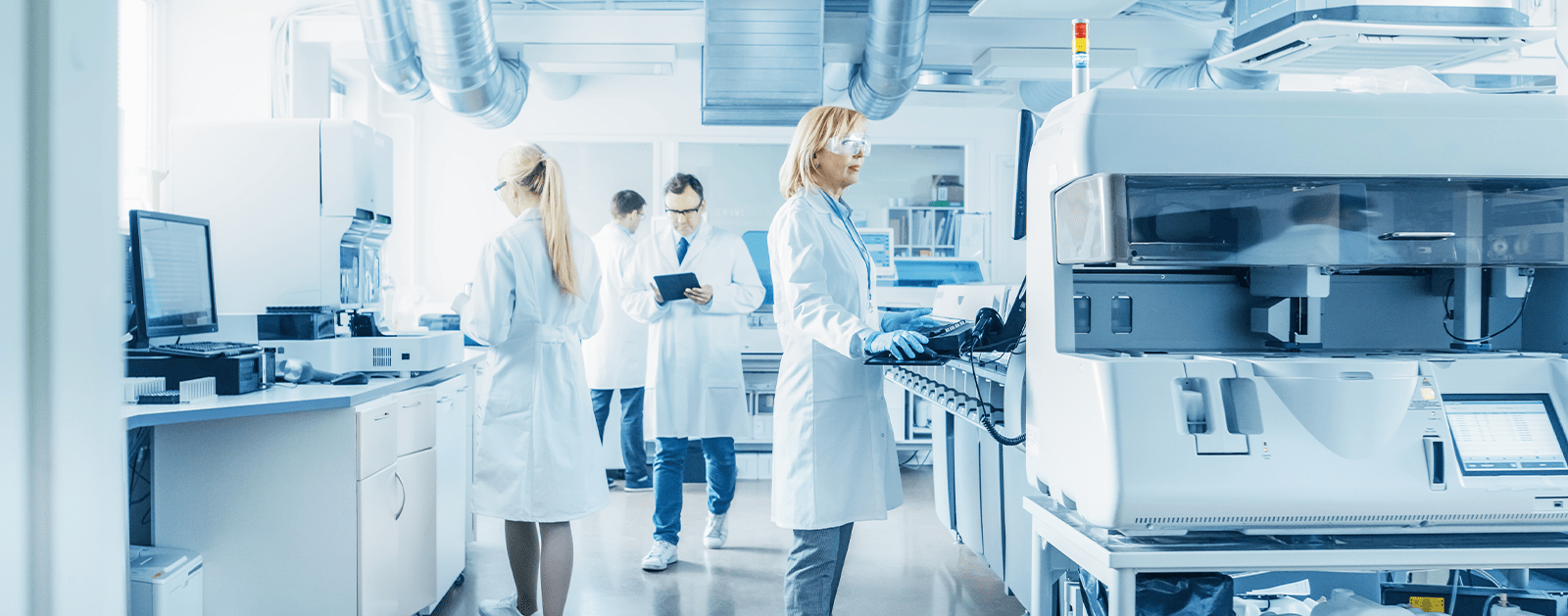 Équipe de techniciens travaillant dans un laboratoire automatisé avec équipements de supervision et d’analyse