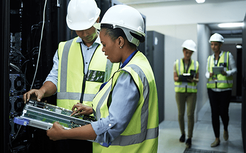 Techniciens intervenant sur des équipements de refroidissement dans un data center avec suivi des systèmes et serveurs