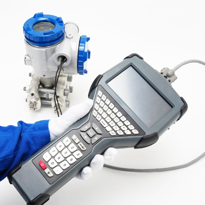 Técnico que utiliza un terminal Pocket HART ATEX conectado a un transmisor de presión industrial