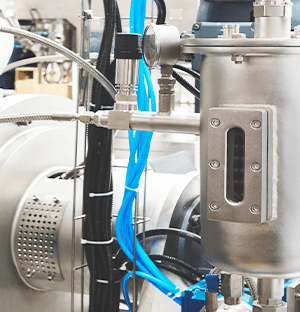 Industriepumpe mit Anschlüssen, Schläuchen und Metallbehälter, die in einem Flüssigkeitsumwälzsystem eingesetzt wird