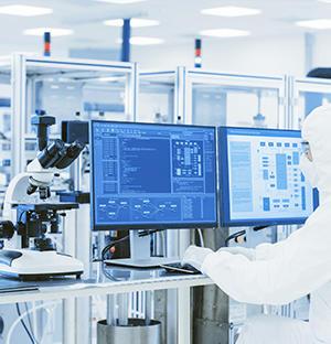 Technicien en laboratoire surveillant des écrans d’analyse et équipements connectés pour le contrôle des installations