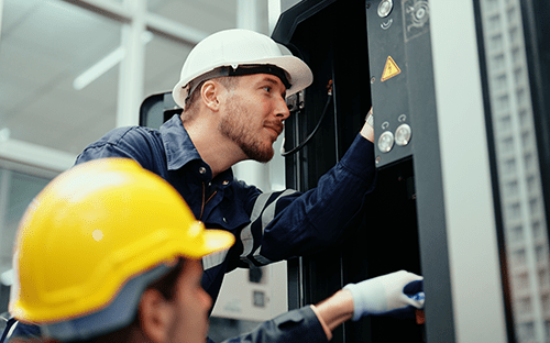 Techniker, die an einer industriellen Elektroanlage arbeiten, um die Energieeffizienz zu optimieren