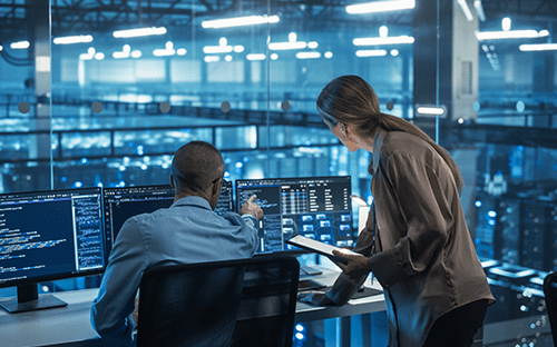 Techniciens supervisant des écrans de contrôle dans un data center pour optimiser le refroidissement et le débit