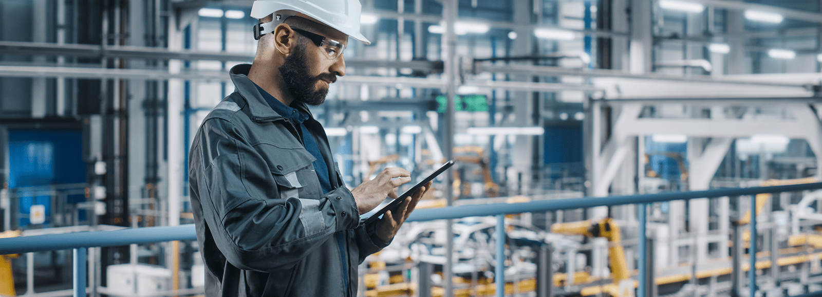 Industrietechniker, der in einer Fabrik ein Tablet zur Überwachung und Steuerung von Anlagen nutzt