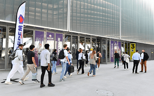 Visiteurs entrant dans le hall du salon SEPEM Toulouse devant les portes d'acc&egrave;s du parc des expositions