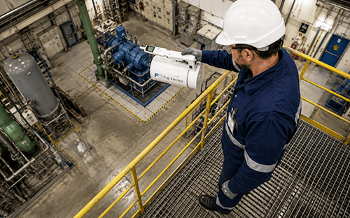 Technicien utilisant un radiamètre portable Fuji Electric pour mesurer les neutrons depuis une plateforme industrielle