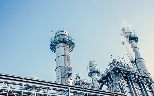 Anlagen und Aufbereitungssäulen eines Industriestandorts unter blauem Himmel