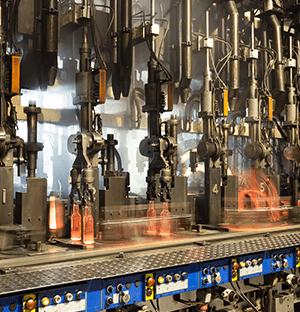 Linea industriale per la produzione di bottiglie di vetro con contenitori riscaldati che scorrono sotto le attrezzature