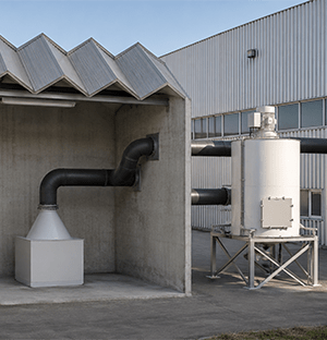 Industrielle Entstaubungsanlage mit Absaugleitungen, die mehrere Filteranlagen miteinander verbinden