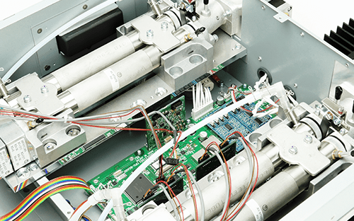 Interior de um analisador de gases com células de medição, placas eletrónicas, cablagem e componentes óticos