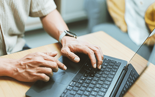 Utilisateur consultant un ordinateur portable pour préparer une demande de devis ou rechercher un débitmètre à ultrasons