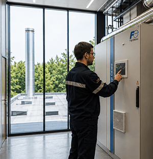 Tecnico che gestisce un armadio CEMS Fuji Electric tramite il suo touchscreen in un impianto industriale