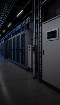 Allée d’un data center avec rangées de baies de serveurs, armoire électrique et tuyauteries techniques de refroidissement