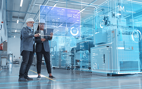 Deux professionnels consultent une tablette dans une usine connectée avec interfaces numériques de supervision